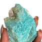 Raw amazonite in hand with quartz