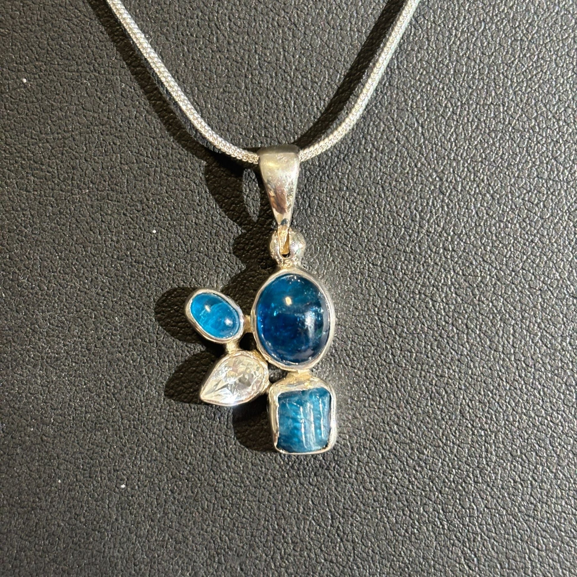 Blue apatite and white topaz pendant on chain black background