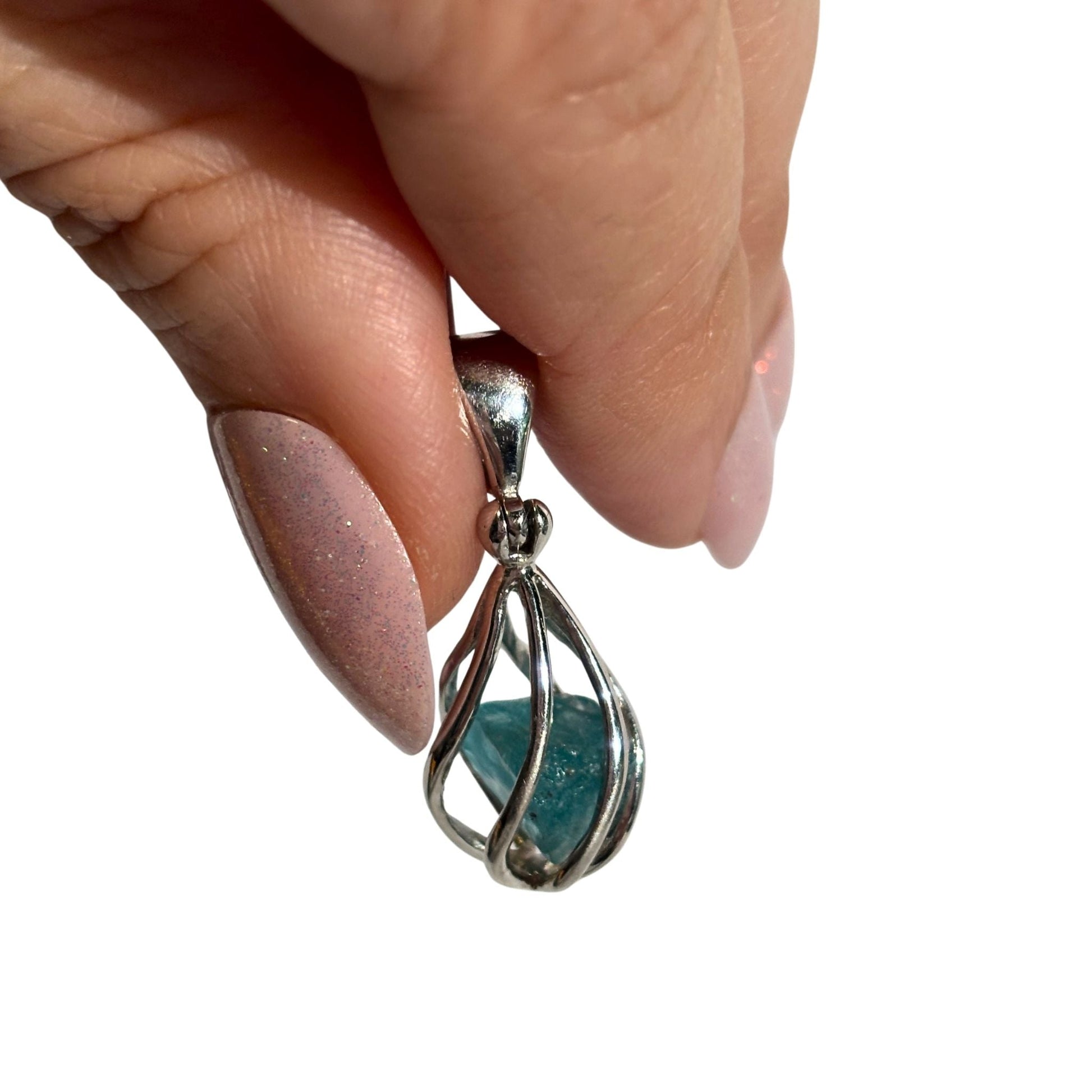 Blue apatite silver swirl pendant in hand